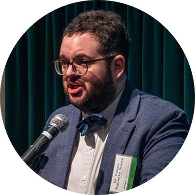 man on stage speaking in microphone